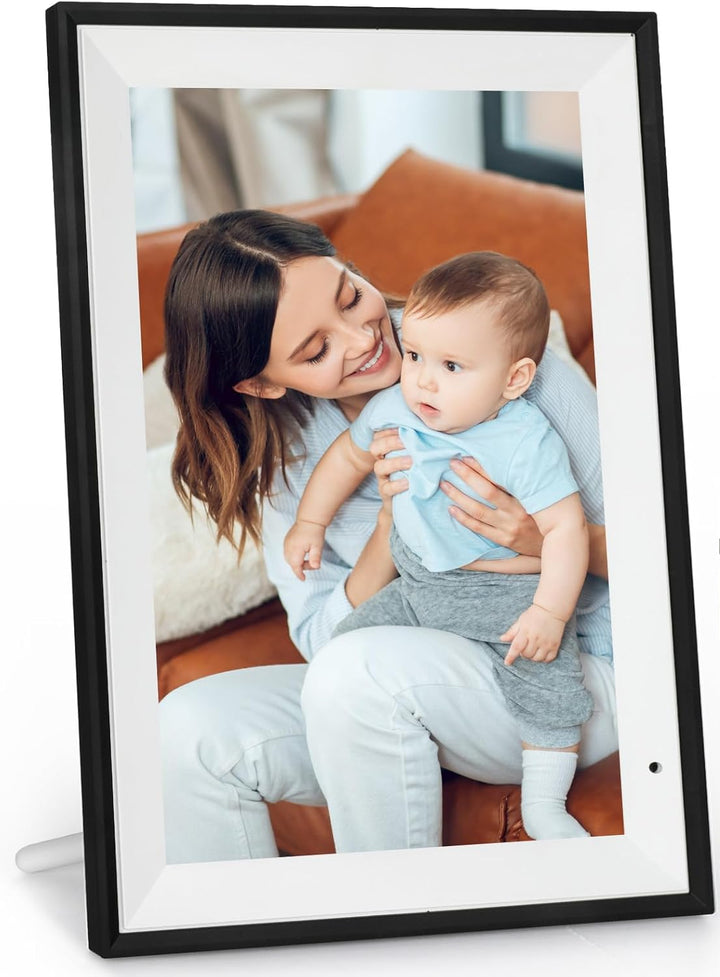 Digital photo frame displaying a picture of a woman holding a baby, with a smartphone showing app interface.